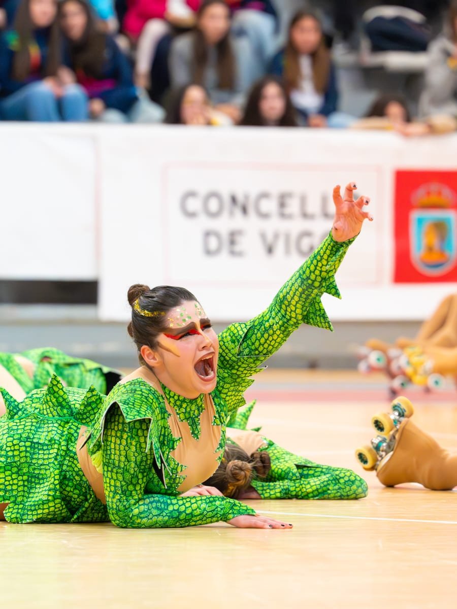 Patinadora con vestuario temático verde gritando en una coreografía de grupo show — foto de Pablo González